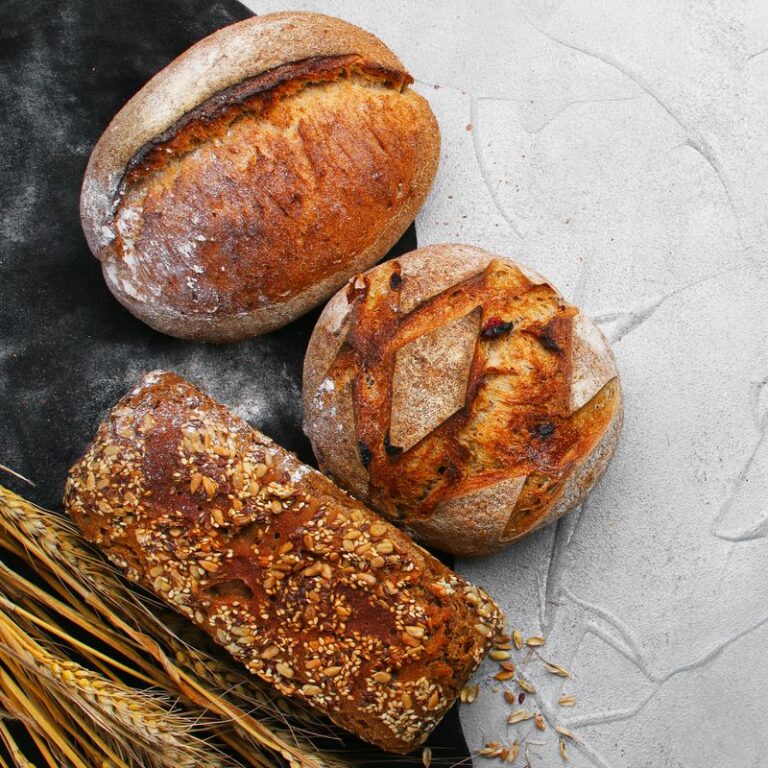 Various types of bread on concrete background with copy space, top view